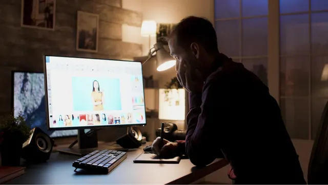 Stock photograph of a person working on an image at a desktop computer.