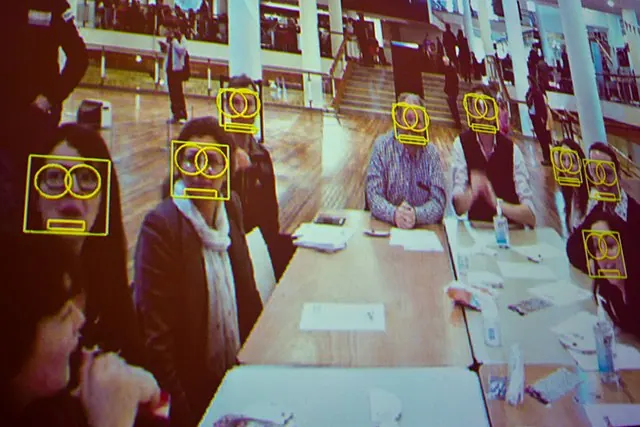 Illustration of facial recognition markers on people around a table.