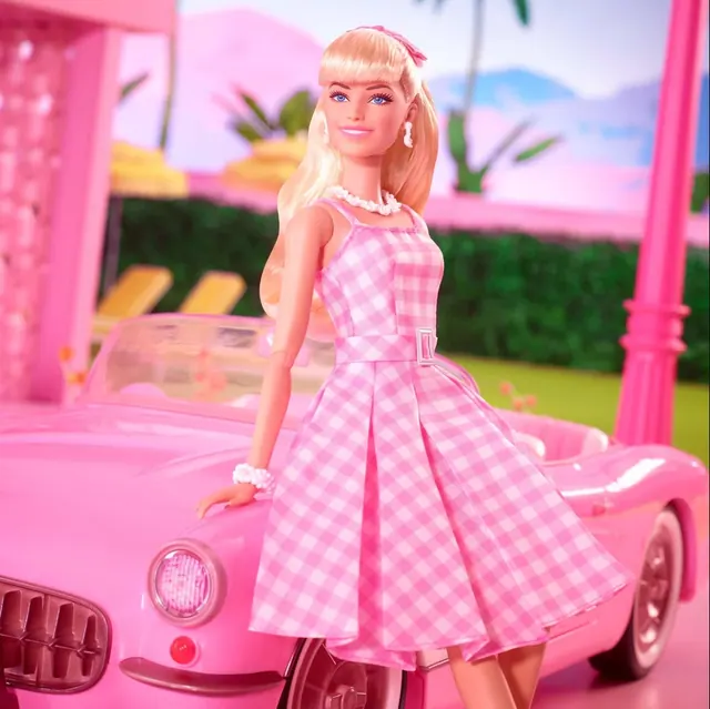 Barbie film imagery showing a character in pink beside a pink car.