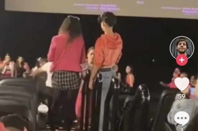 Archive video frame of people standing among cinema seats during the reported confrontation.