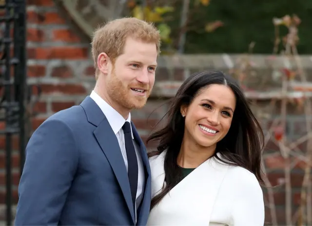 Archive photograph of Prince Harry and Meghan Markle standing outdoors.