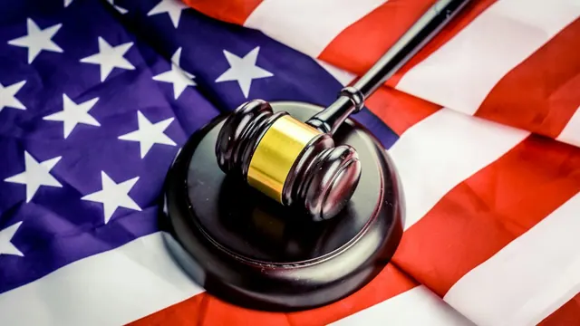 A gavel beside a United States flag; illustrative image.