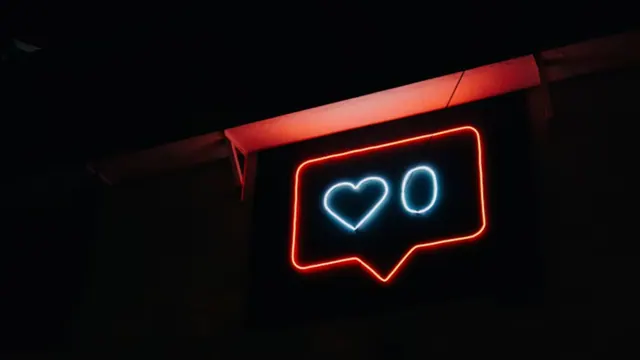 An illuminated social-media heart notification sign.