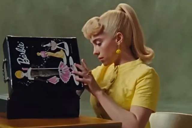 Illustrative Barbie imagery showing a woman in yellow holding a doll case.