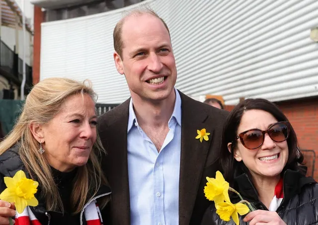 Archive photograph of William posing with two women holding daffodils.