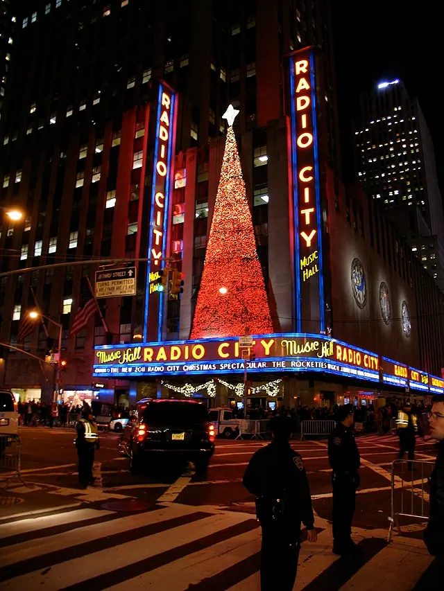 Radio City Music Hall exterior at night with its illuminated marquee.