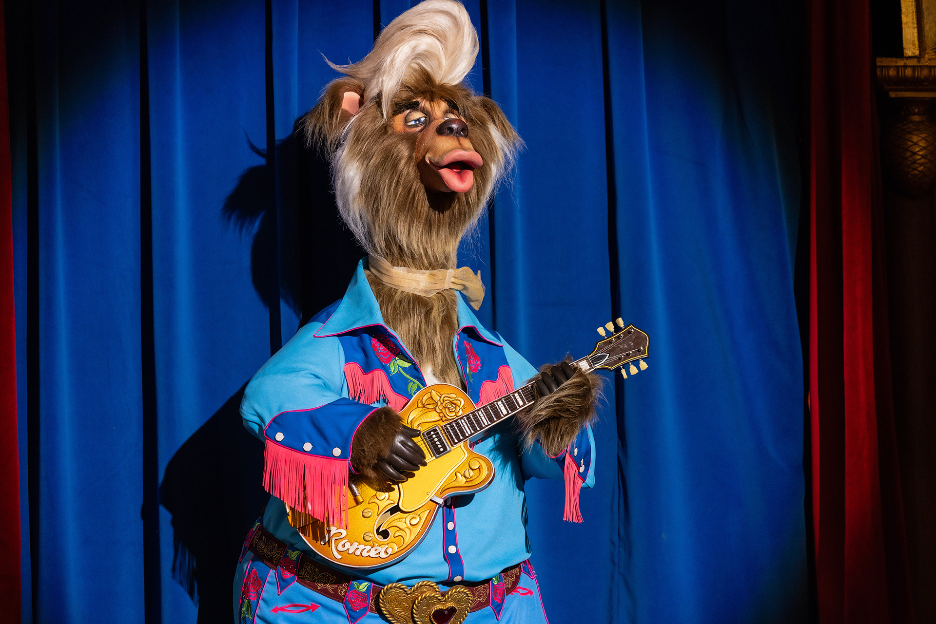 Romeo McGrowl animatronic with a guitar and blond hairstyle.