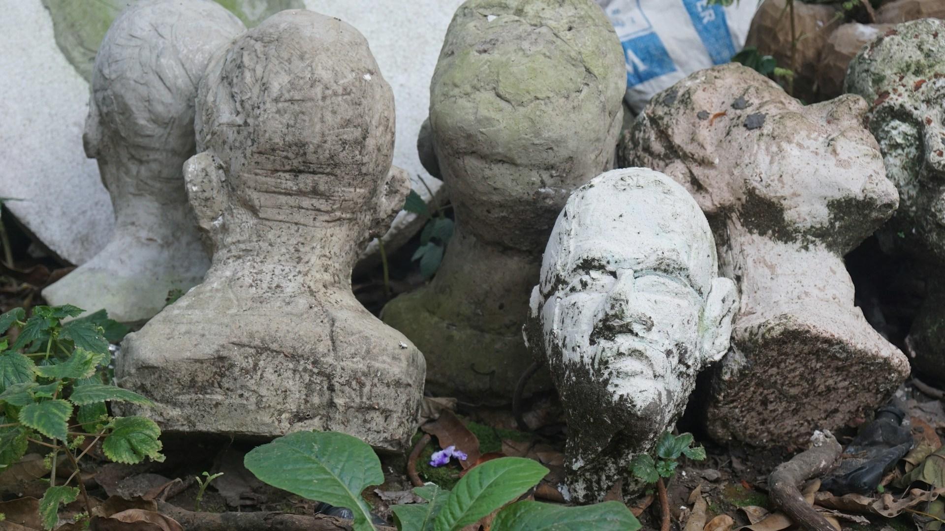 Sculpted heads displayed outdoors.
