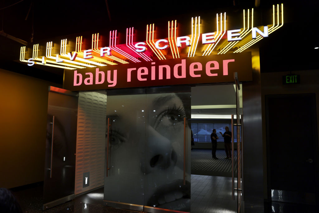 An illuminated Baby Reindeer sign above a venue entrance.