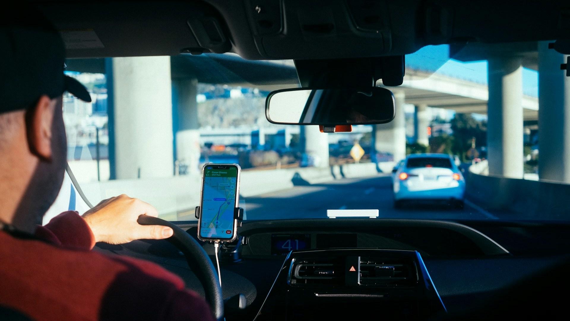 A driver seen from the back seat of a vehicle