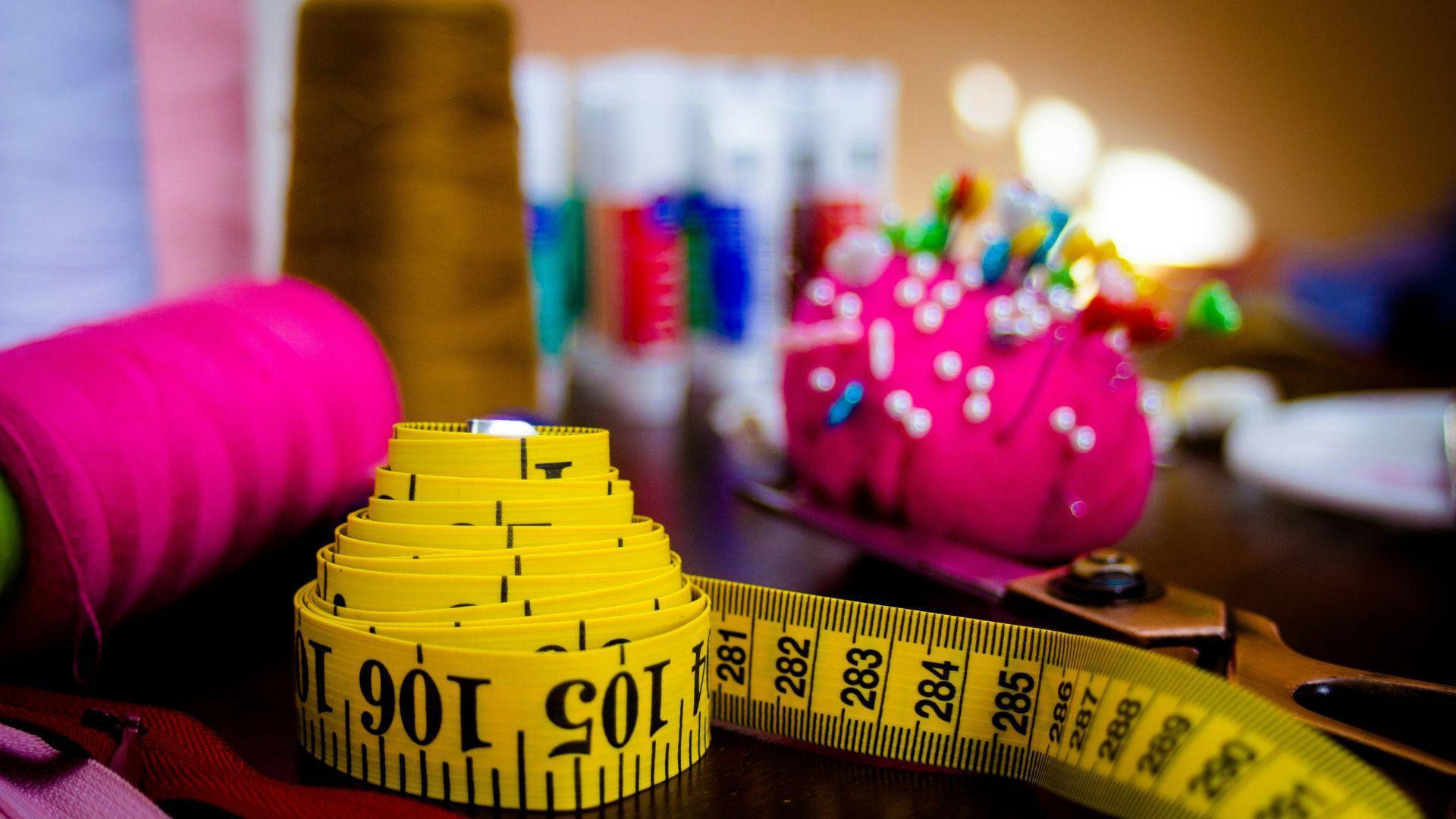 Sewing supplies including a tape measure and pins.