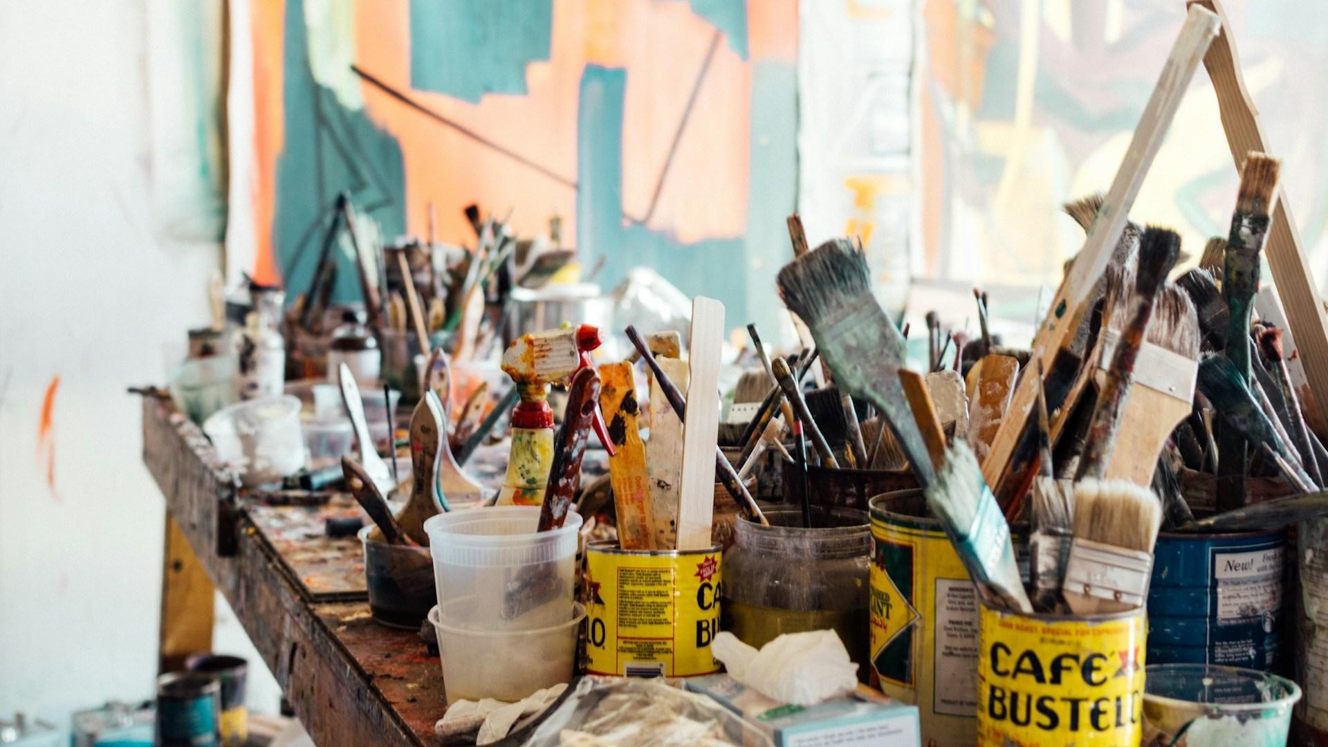 Paintbrushes and art supplies in a studio.
