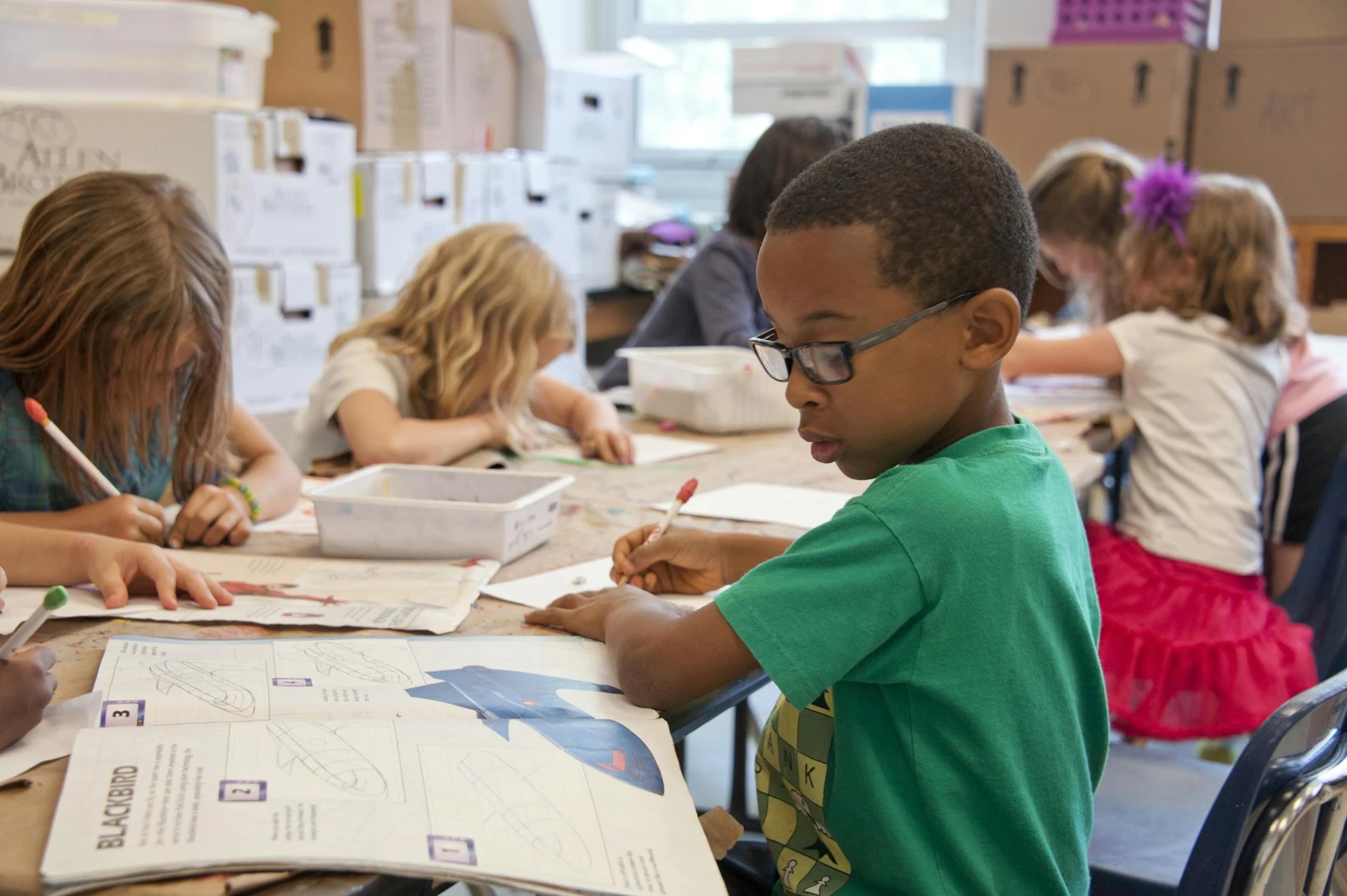 Children working at classroom desks; illustrative stock photograph.