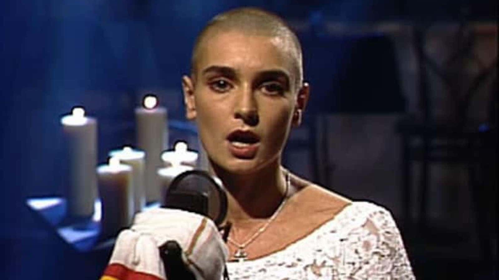 Sinéad O’Connor holding a photograph during a performance