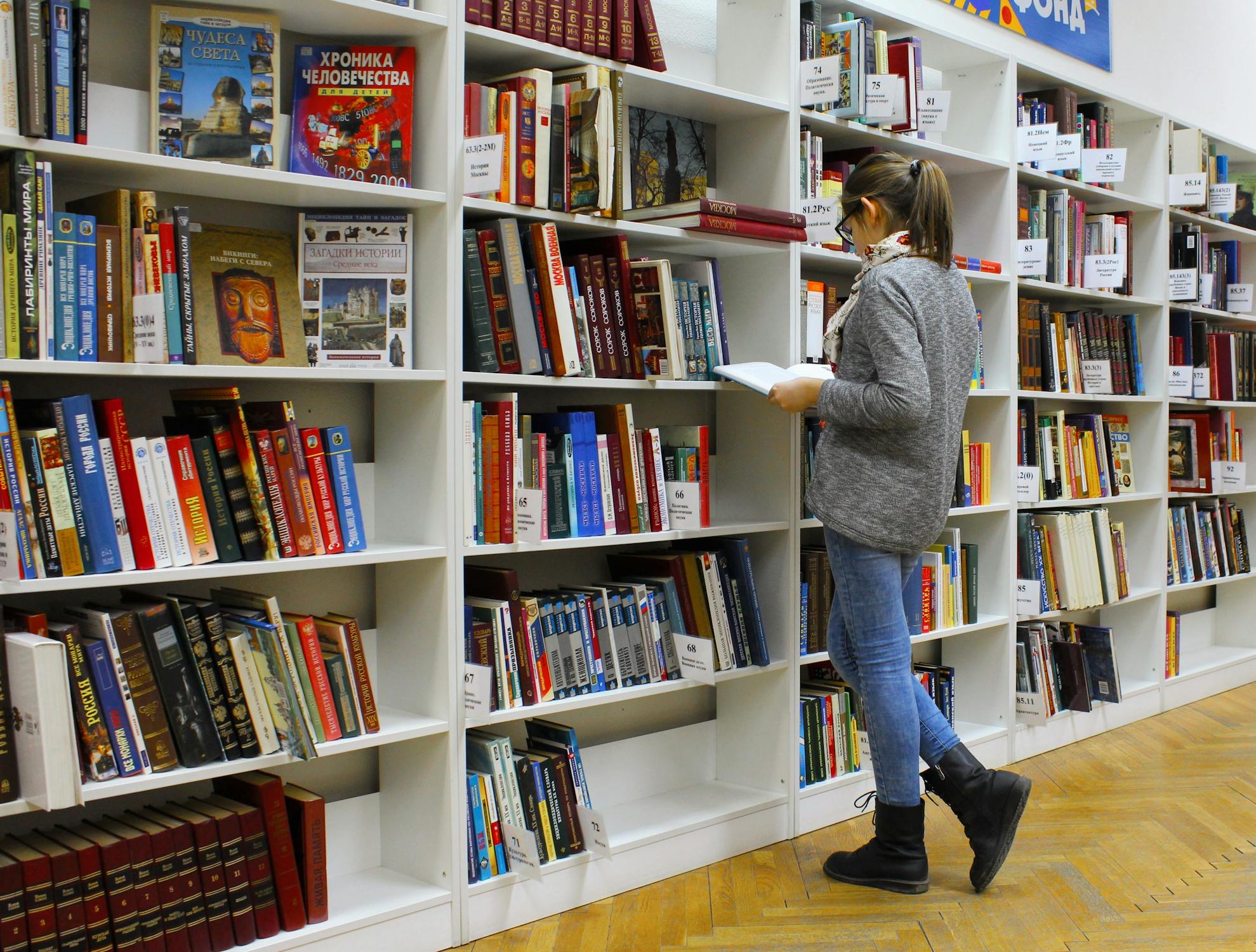 A person browsing library shelves; illustrative photograph.